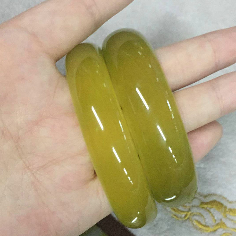 岫玉朝鲜黄玉圆镯批发 姜黄色镯子少棉少黑点 冰透玉石镯子女款