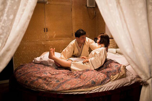 理疗师masayuki ozaki 把他的充气娃娃mayu抱到床上