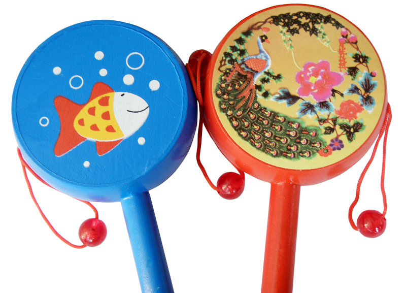 鼓的两边各有一根红绳,串着一颗小珠,鼓两边有图案,拿住拨浪鼓的柄,摇