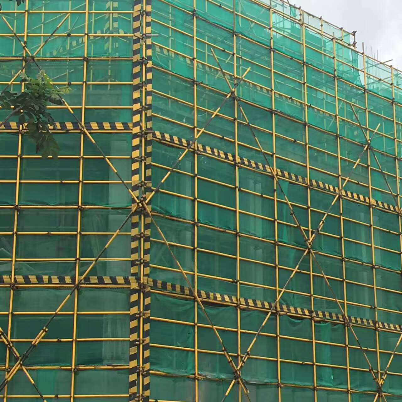 建筑工地楼层带,显示每层间隔,电梯井口安全警示,脚手架外围