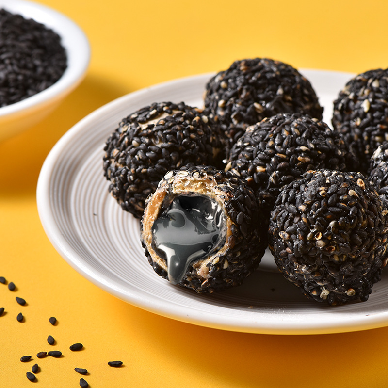新品网红 爆浆黑芝麻丸85g高钙健康夹心膨化黑芝麻球网红零食代发