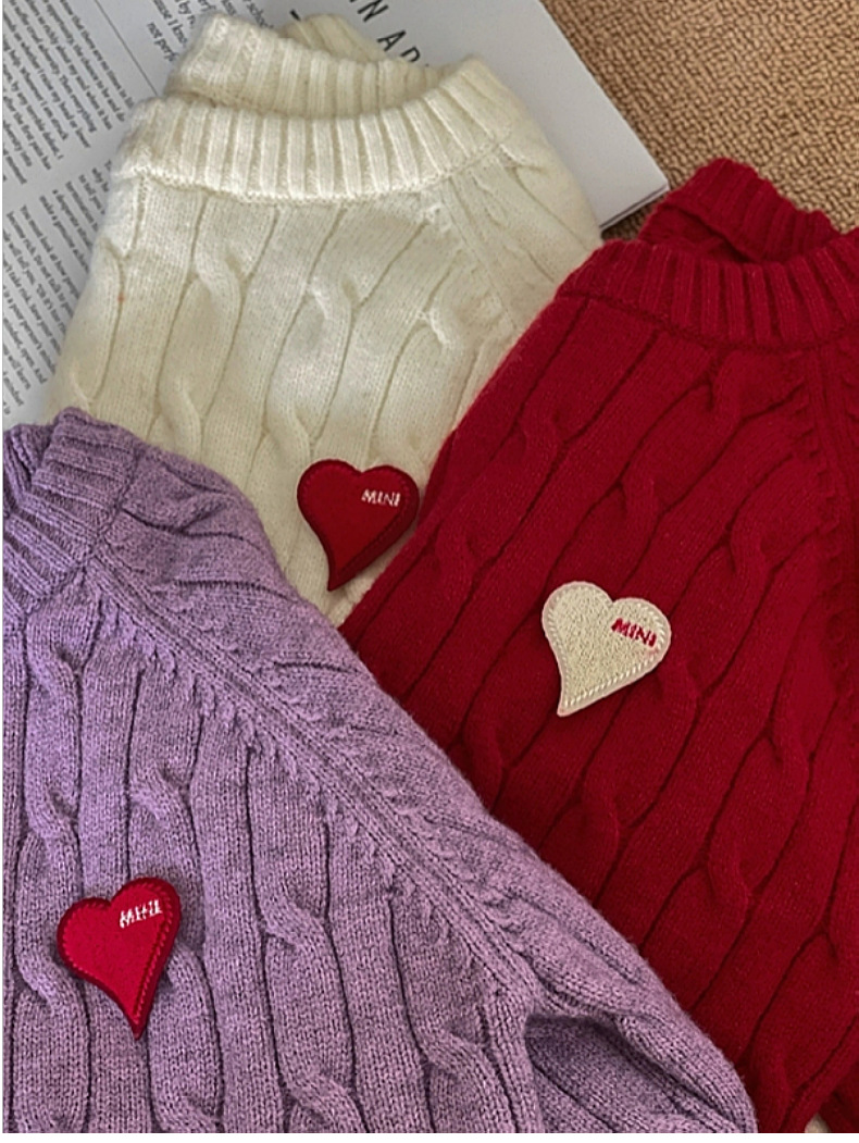 Family wearing festive matching knit sweaters with heart motifs in vibrant red, white, grey, and purple hues
