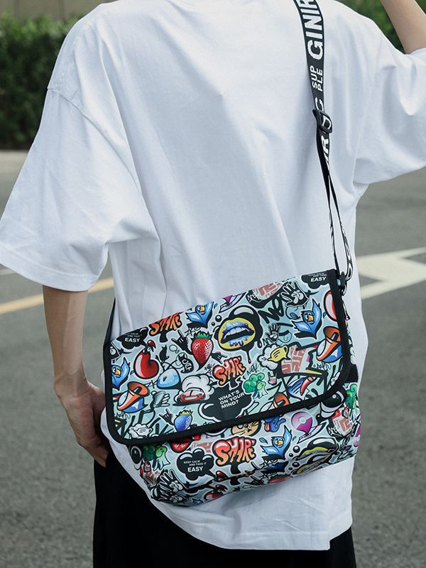斜挎包包女新款卡通涂鸦印花翻盖邮差包街头潮流嘻哈风字母单肩包