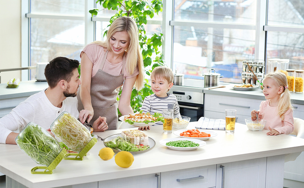 Smiling young family eating Sprouts Salad together in kitchen, sprout maker next to them