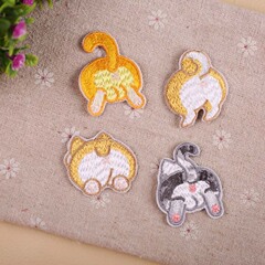 Embroidered patches with cute cartoon animal designs for clothing decoration, featuring a backdrop of traditional Chinese embroidery and computerized stitching.