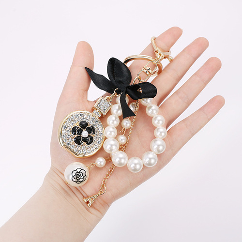 Korean version of the new creative small gift pendant perfume bottle bow shape alloy keychain pearl pendant wholesale