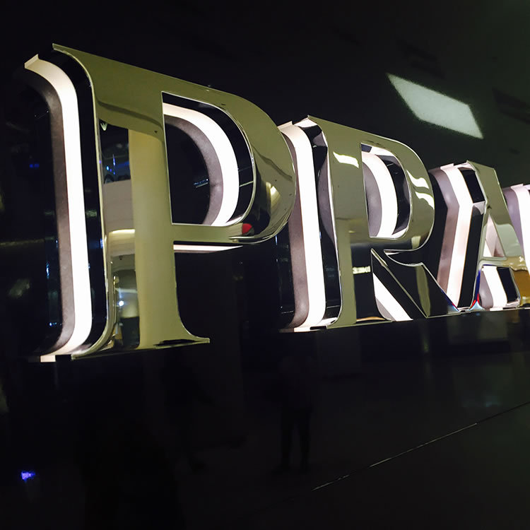 Outdoor neon illuminated signs and storefronts, made of metal, stainless steel, and frameless acrylic LED backlit letters.