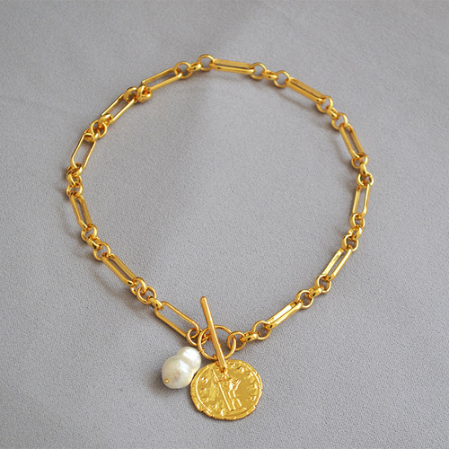 Elegant European and American-style exaggerated vintage gold-plated brass chain necklace featuring a large baroque gold coin with cold, minimalist charm and an OT clasp—paired with delicate baroque pearls.