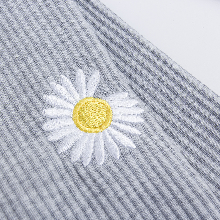 Leggings de estilo influencer a la moda con pequeños bordados de margaritas, de nueve puntos de largo, pantalones ajustados de corte ajustado y acanalados para primavera y otoño.