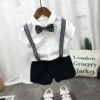 White shirt, trousers, wavy bow tie, suspenders