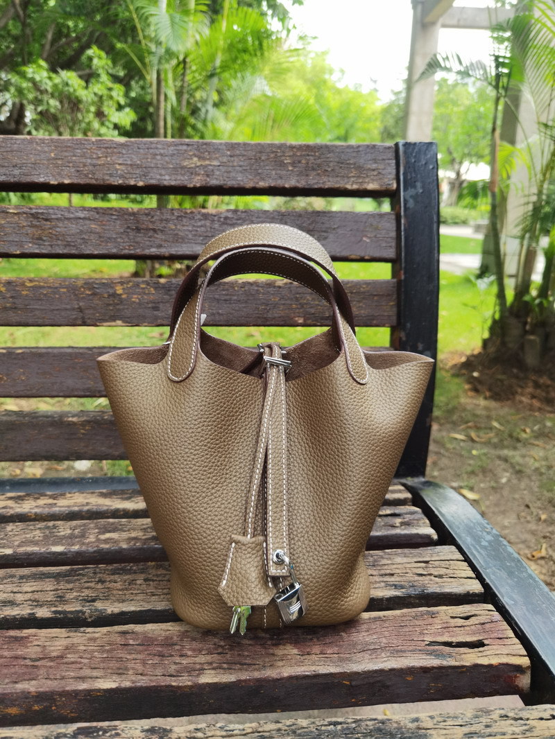 El nuevo bolso de cesta de verduras de marea de cuero togo de piel de vaca de capa superior 2025, bolso de cubo con cerradura de mano, bolso de cuero para mujer