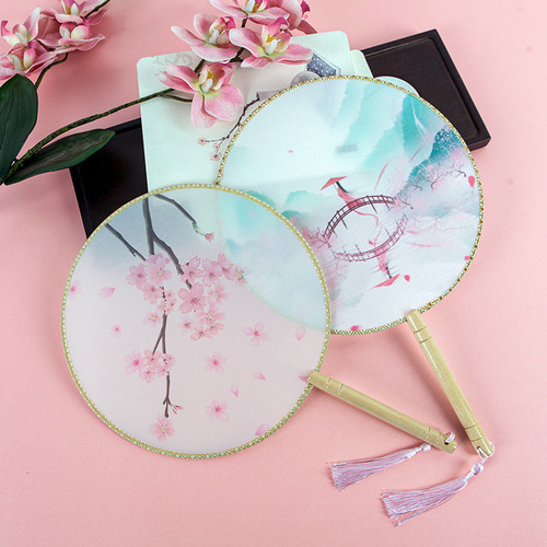 An ancient-style wooden-handled half-transparent Hanfu round fan with Chinese architectural elements, featuring a wooden handle and silk gauze, suitable for photography.