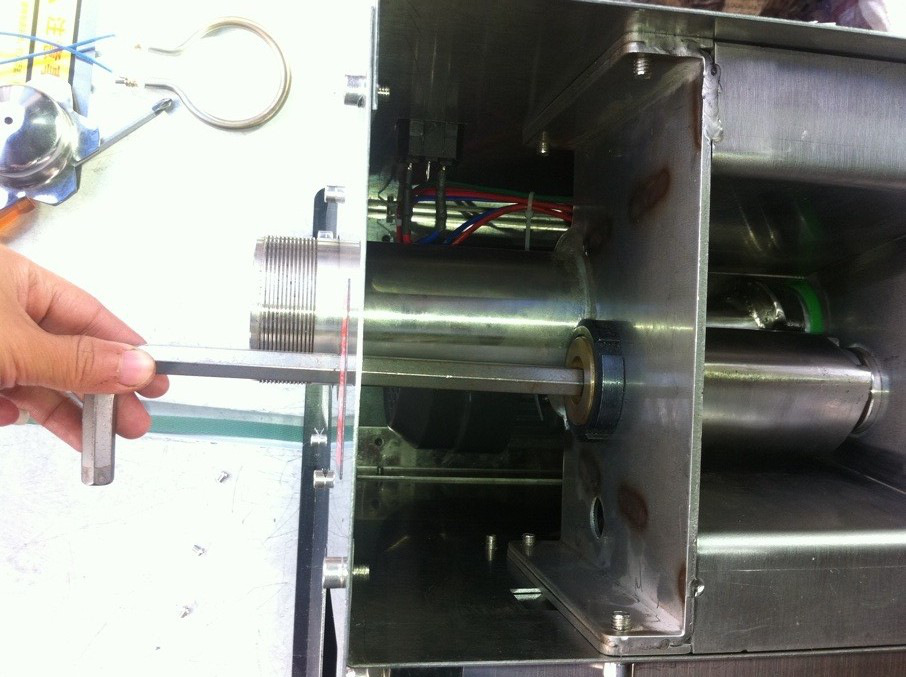 用M12內六角把手伸進機器前端孔中退出螺絲