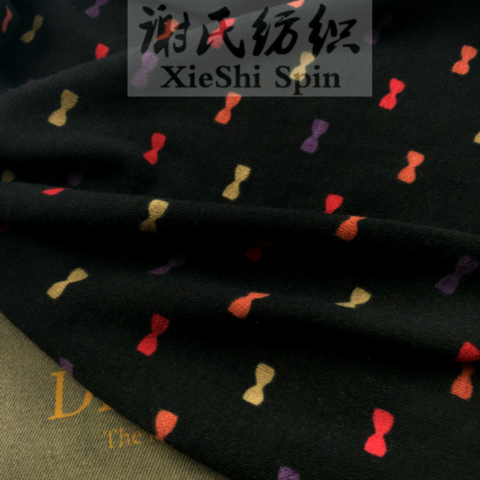 2023冬布料 黑色底彩色卡通蝴蝶结印花弹力针织 卡通毛衣开衫面料