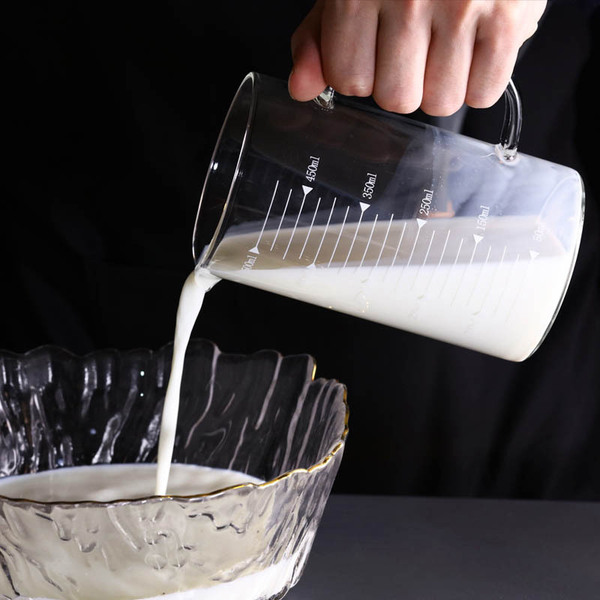 Transparent glass measuring cup scaled