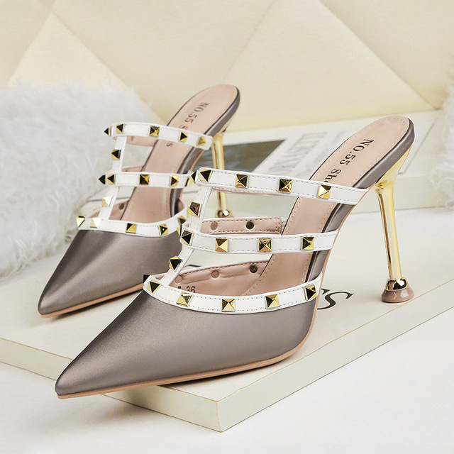 Slender riveted women’s sandals with thin heels and empty shoes 