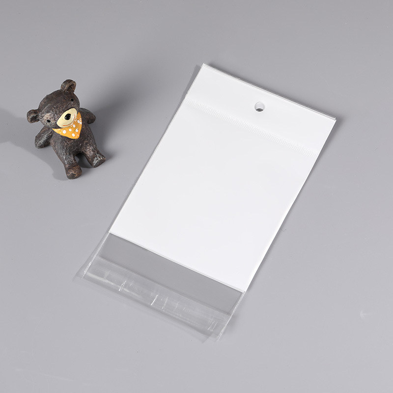 Factory wholesale white OPP transparent self-adhesive pearlescent film with dual-purpose hanging holes—ideal for nail accessories and wearable jewelry; available in plastic packaging bags.