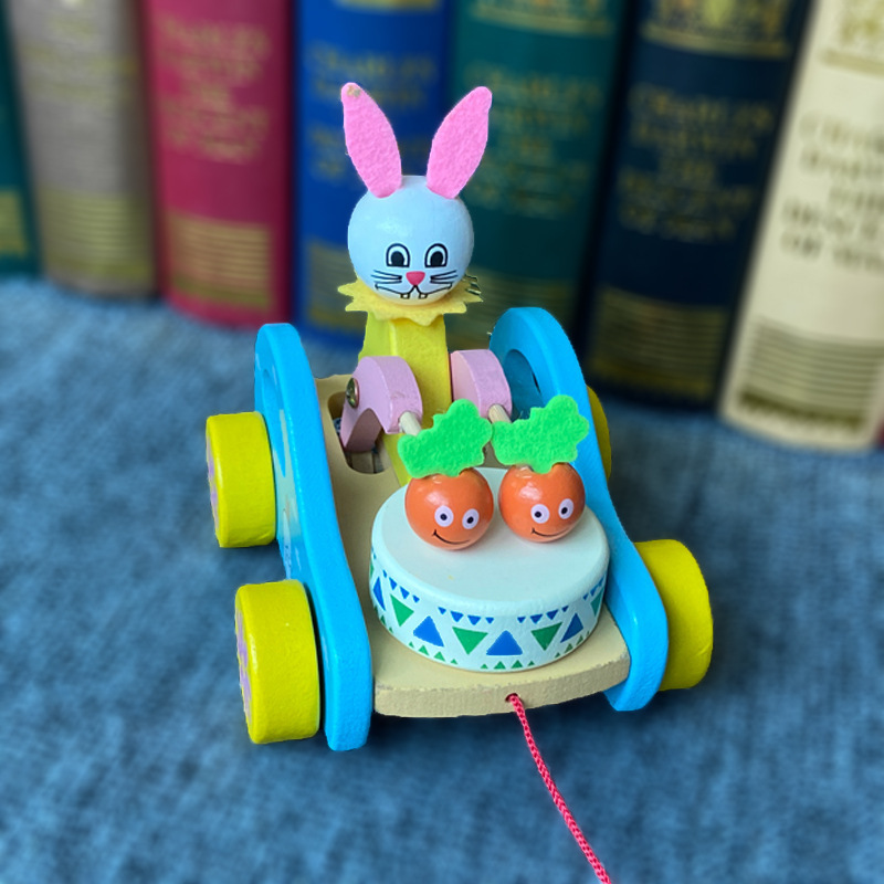 子供の木製の熊は車の赤ちゃんを引き延ばして学校の歩の漫画の熊を引き延ばしておもちゃの車の動物の小さい白いウサギを引きずって車を引き延ばします。|undefined