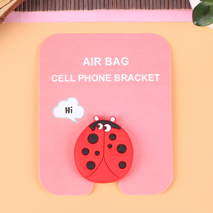 En stock al por mayor TikTok Cartoon creativo soporte de teléfono móvil puede soportar airbag soporte de teléfono móvil soporte de escritorio