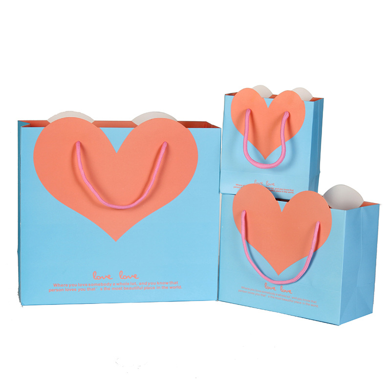 Fábrica en stock al por mayor bolsa de regalo de amor bolsa de regalo de boda bolsa de papel de embalaje portátil logotipo impreso en forma de corazón