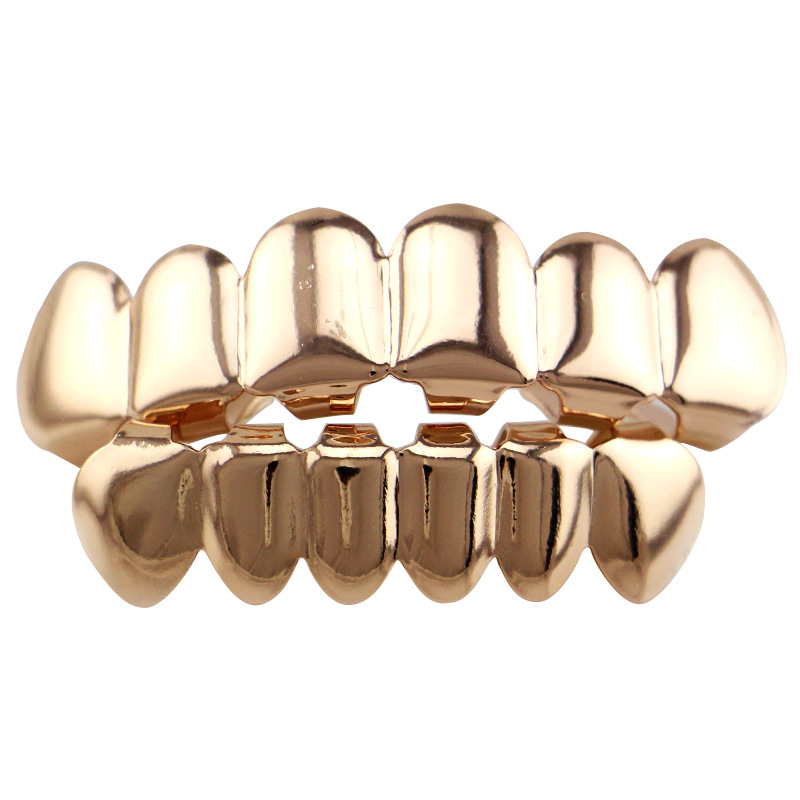Europea y americana joyería brillante hueco colmillos hip hop tirantes para hombres y mujeres mismo Grillz18K electrochapado cobre oro dientes