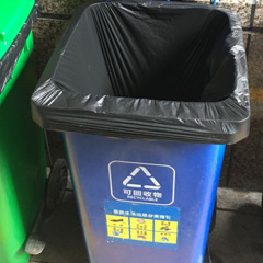 A large roll of disposable breakaway hotel property cleaning bags, black bundled large plastic garbage bags