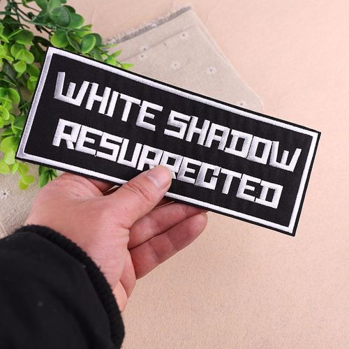 Embroidered patch with a small black logo, trendy for clothes and fashion accessories.