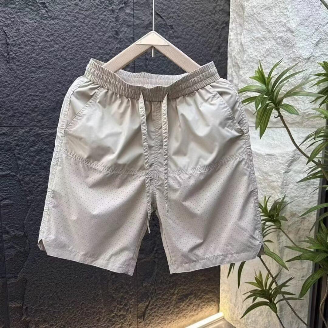 Verano nuevo estilo de secado rápido suelto tendencia casual perforado pantalones de cinco puntos moda masculina pantalones deportivos fríos y transpirables