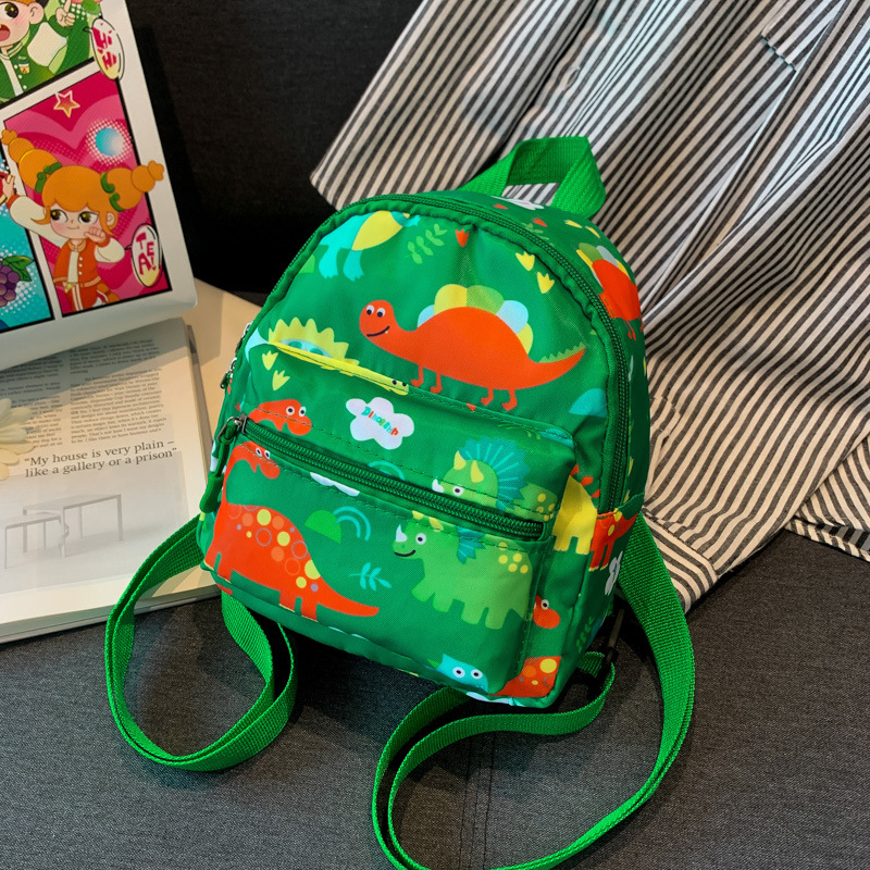 Mochila nueva al por mayor 2025, mochila de tela Oxford con diseño de dinosaurio de dibujos animados, mochila pequeña de gran capacidad para actividades al aire libre y ocio.