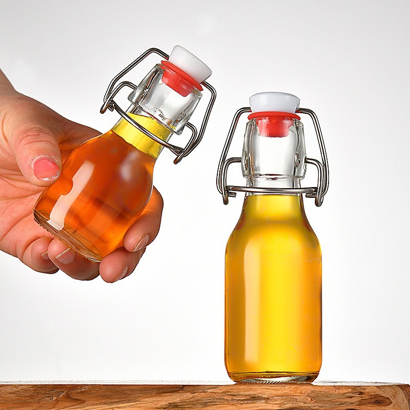Amazon pequeña hebilla 60ml botella de vidrio pequeña botella de vino botella de bebida enzimática aceite comestible aceite de Camelia sub-botella al por mayor