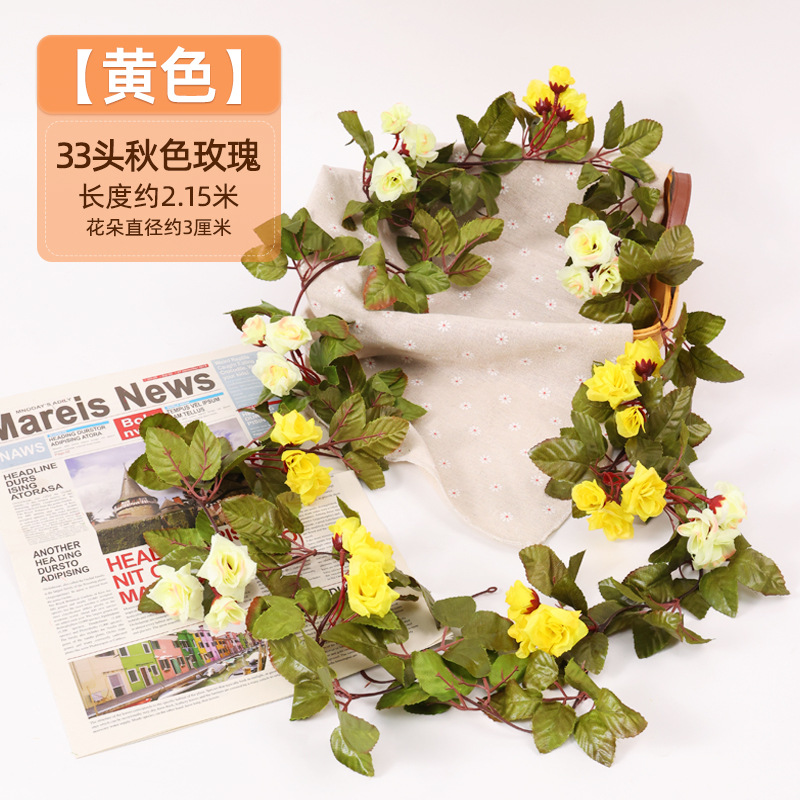 Simulación de flores falsas rosas de caña colgando la pared tubería de drenaje envuelta hoja verde que cubre la parte superior de la decoración de boda de plástico