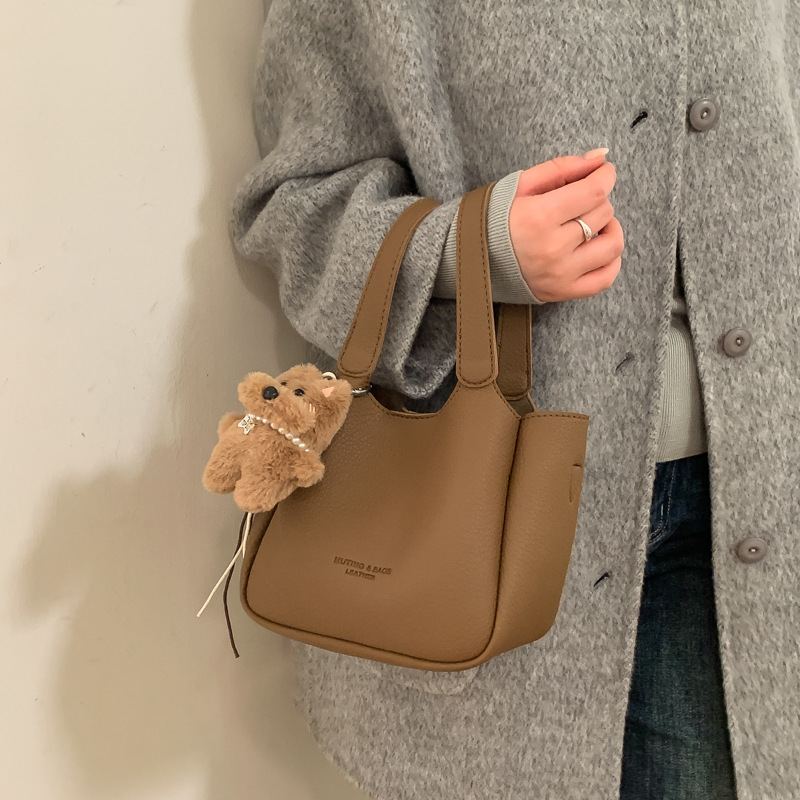 Bolsa de cubo de mano de alta sensación para mujeres 2025 nuevo retro lichi estampado bolso de madre universal simple mochila de hombro