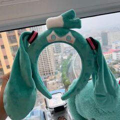 初音ミクと同じタイプの人形のカチューシャが顔を洗って個性的な毛のカチューシャの髪飾りをします。