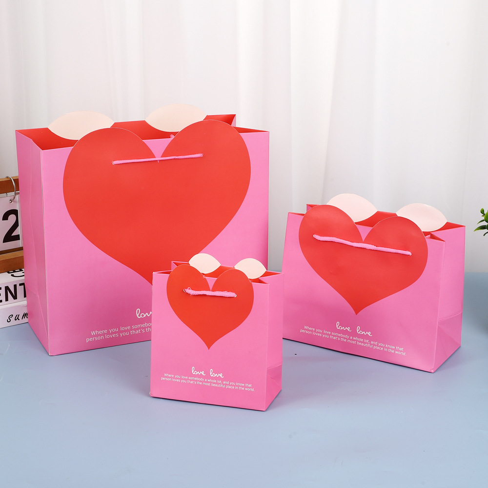 Fábrica en stock al por mayor bolsa de regalo de amor bolsa de regalo de boda bolsa de papel de embalaje portátil logotipo impreso en forma de corazón