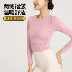 秋冬のタイトなスポーツの長袖ヨガ服の女性の裸感の中にtシャツを掛けてランニングします。