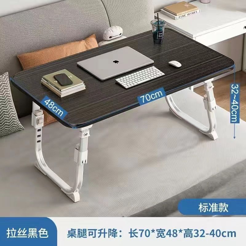 ベッドの上の小さい机のノートパソコンの机の上で折り畳みます。|undefined