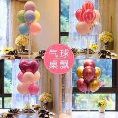 テーブルに風船が漂っています。ジョーは誕生日パーティーを飾っています。