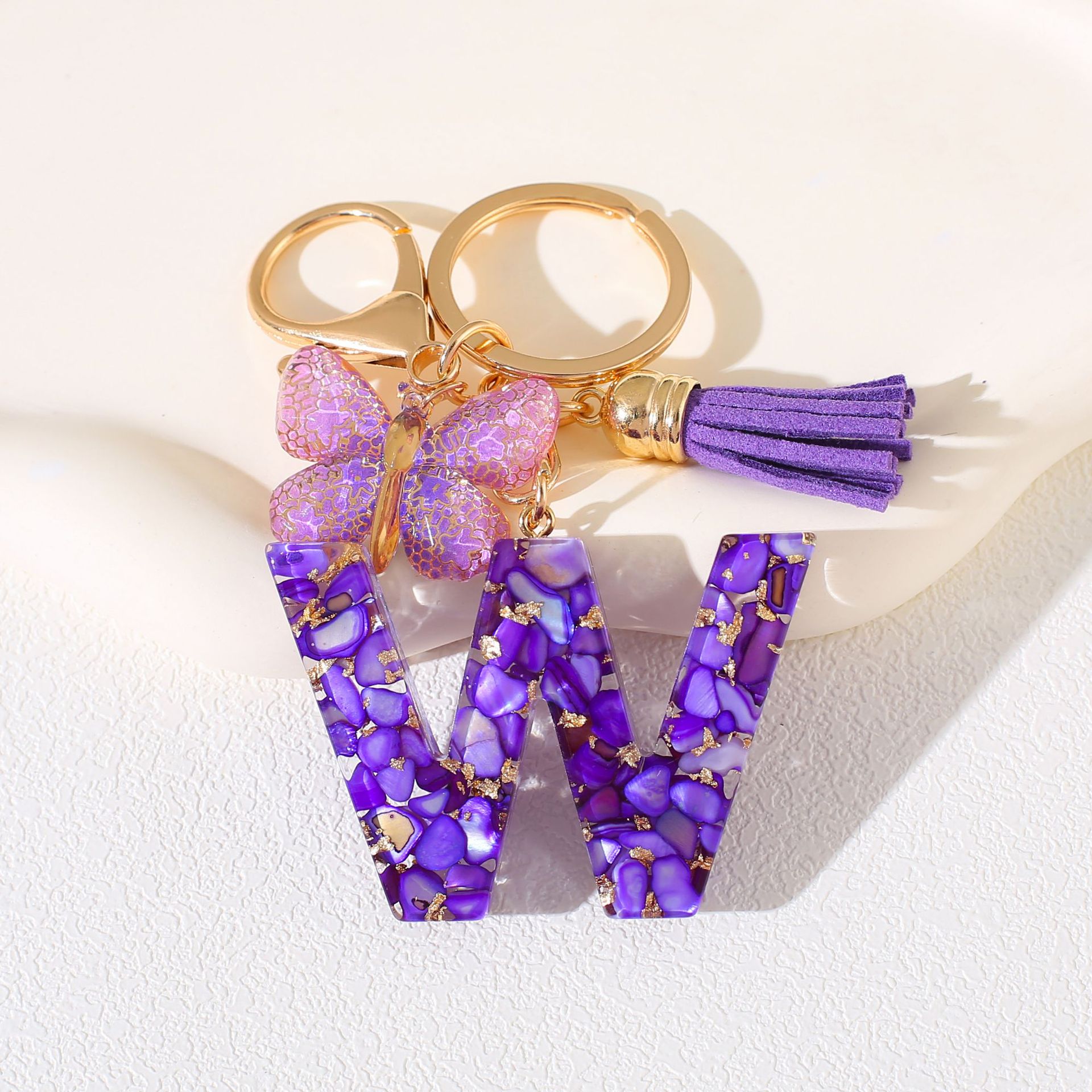 Fábrica directa de Yiwu accesorios de resina de goteo de embalaje llavero anillo de metal letras mariposa brilla colgante damas