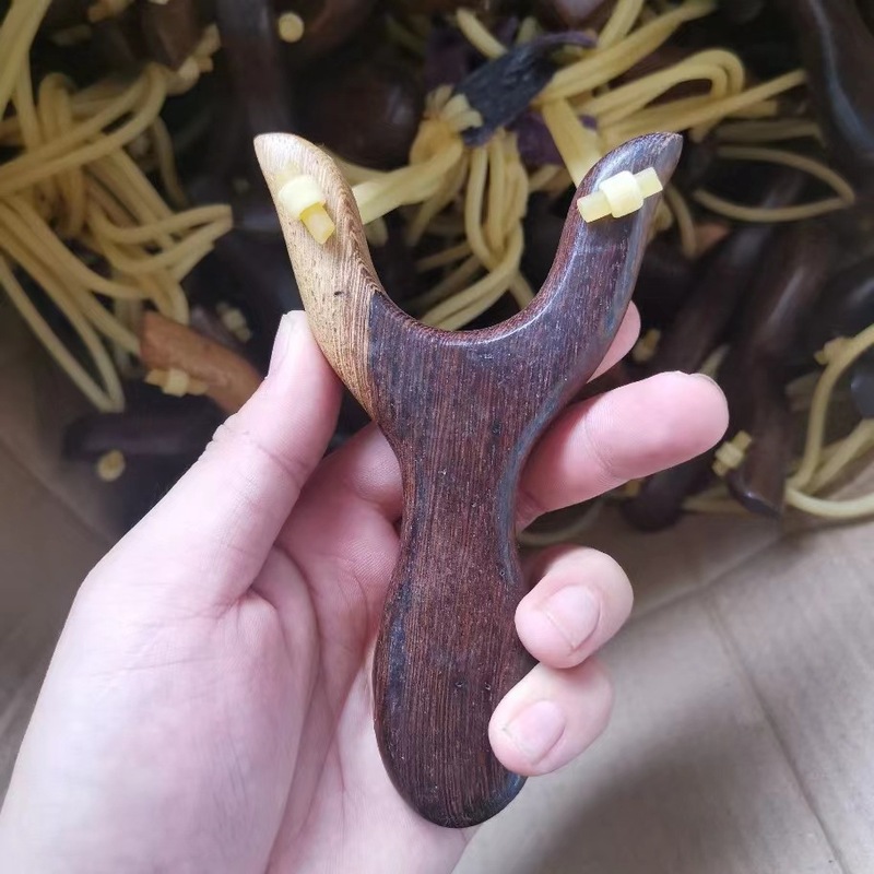手羽の木の赤い花梨の木のパチンコの木のパチンコの屋外の文はパチンコの平たい皮の筋のパチンコを遊びます。|undefined