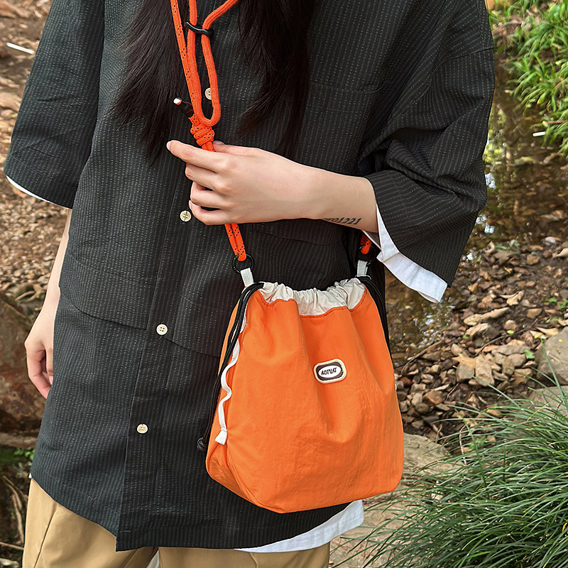 日系抽绳水桶包女运动新款百搭斜挎包休闲通勤手机包潮撞色单肩包