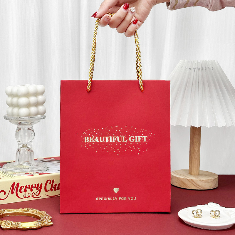 Spot bolsa de regalo roja bolsa de embalaje festiva de boda tarjeta roja papel bronceado bolsa de mano regalo fábrica de bolsas de papel al por mayor