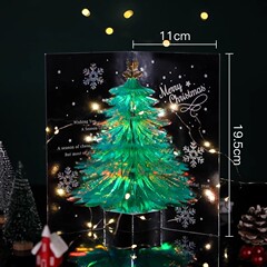 クリスマスのグリーティングカードがキラキラ光るクリスマスツリーの祝日に友達にプレゼントします。
