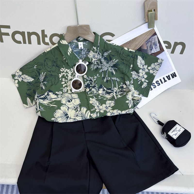 Camisa verde flor pantalones cortos negros gafas de sol