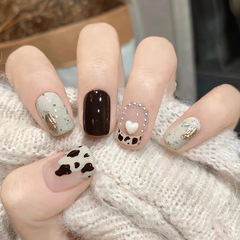 Cute French-style white peach-shaped pearls with black tea, milk, and cow-print designs—perfect for students who love trendy, short, ready-to-wear nail wraps that brighten the skin.
