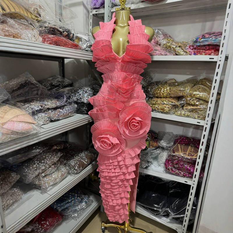 Luxurious and understated evening gown with a halter neck, open back, and pleated, three-dimensional ruffle detailing, designed for a sophisticated and elegant look Luxurious and understated evening gown with a halter neck, open back, and pleated, three-dimensional ruffle detailing, designed for a sophisticated and elegant look