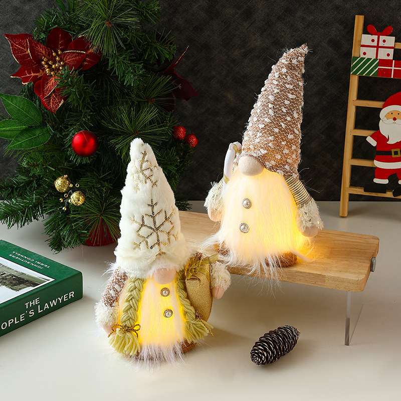 新しいクリスマス装飾の長いひげのぬいぐるみが光るプレゼントの杖を持ってサンタクロースの顔のない人形が飾られている|undefined