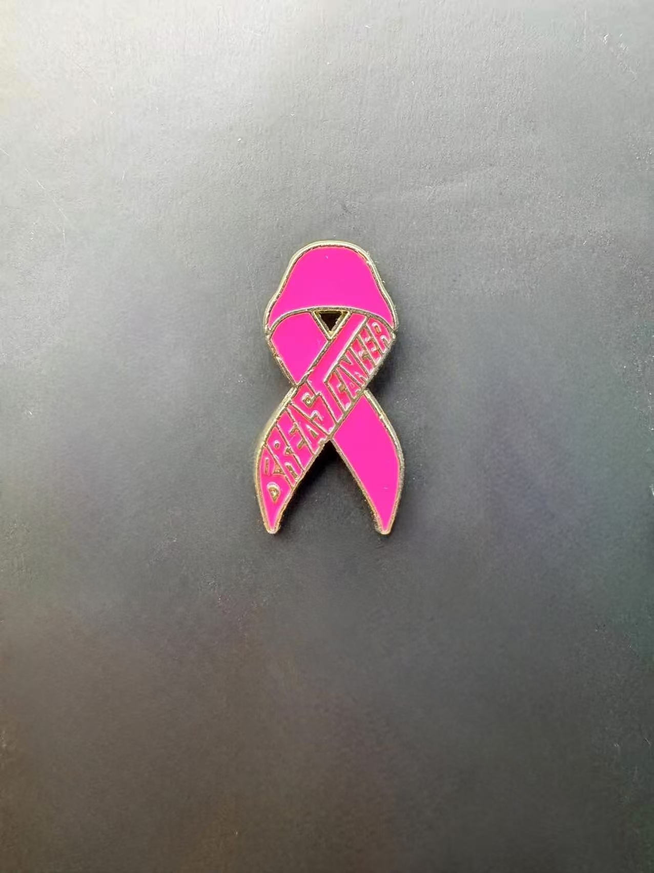 Broche promotionnelle avec logo du Ruban Rose International, symbole de sensibilisation au cancer du sein_voghion.com