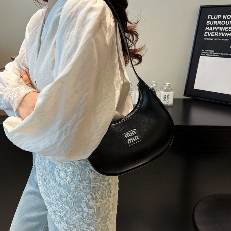 Bolso de axila de fuego súper transfronterizo para mujer 2025 nueva versión coreana de la bolsa de media luna de diseño de nicho bolsa de bola de masa cruzada de sentido avanzado