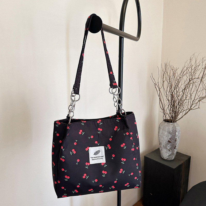Moda pequeña y fresca impresión de cereza bolsos de invierno 2025, bolsos de mujer nuevos, bolsos de gran capacidad, bolsos de mujer de estilo exterior.