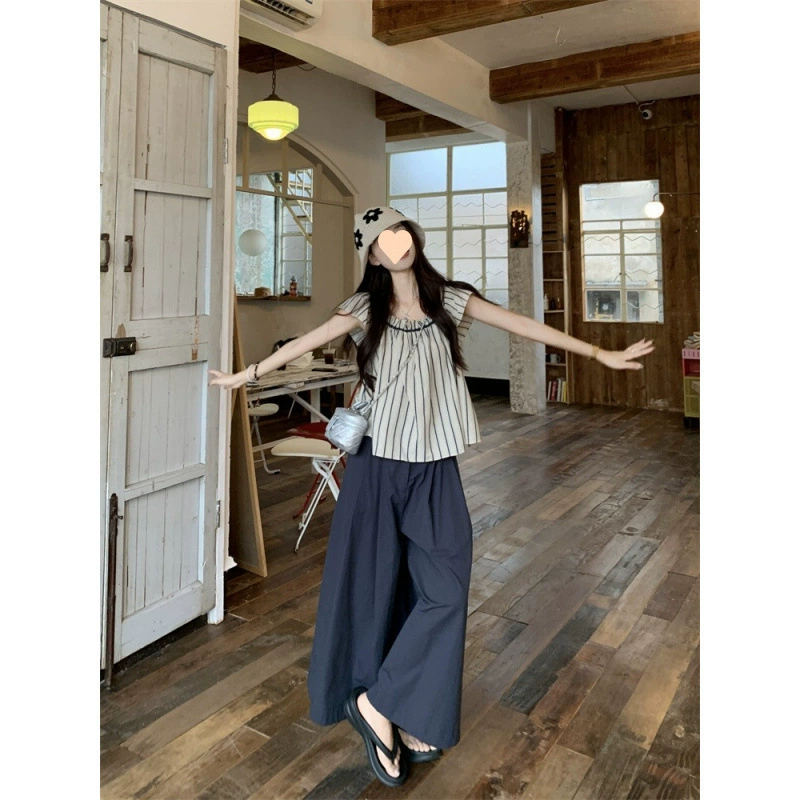 Модный в этом году комплект из двух предметов для женщин: рубашка с маленькими развевающимися рукавами и широкими брюками в полоску в японском стиле в полоску и широкими брюками летом.